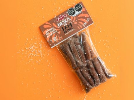 Bolsa de Besos de Tamarindo con sal estilo pellizco sobre fondo naranja